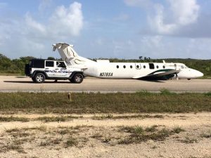 Southern Air on the airstrip in Long Island Bahamas without its landing gear deployed. 