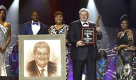 Enrico Garzaroli, owner of the historic and world-renowned Graycliff was presented the Clement T. Maynard Lifetime Achievement Award at the 17th Cacique Awards held at Baha Mar Convention Centre, Cable Beach, on Saturday, April 8, 2017.  Pictured from left: Cherell Williamson, Miss Universe Bahamas; Jamal Rolle, Celebrity Artist, who produced the image of Mr. Garzaroli; Joy Jibrilu, Director General of Tourism; Enrico Garzaroli; and Presenters.  (BIS Photo/Kemuel Stubbs)