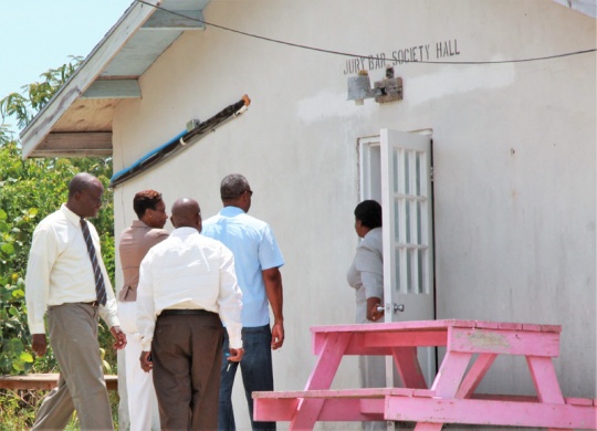 Education officials visiting the one room, temporary school facility in Gregory Town during August of 2014.