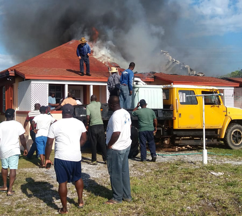 Volunteers attempt to extinguish the building fire.