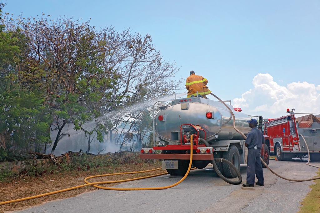 Volunteer fire crews tackling a bush fire within the Ocean View Neighbourhood, north of Governor's Harbour on Monday, May 10th which destroyed two buildings.