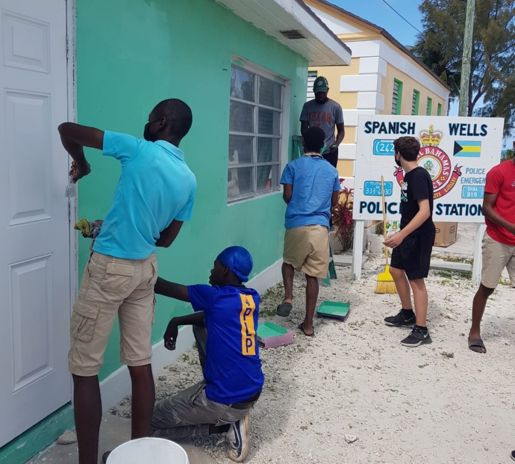 Boys from the Samuel Guy Pinder All Age School assisting with the painting of the exterior of the Spanish Wells Police Station.