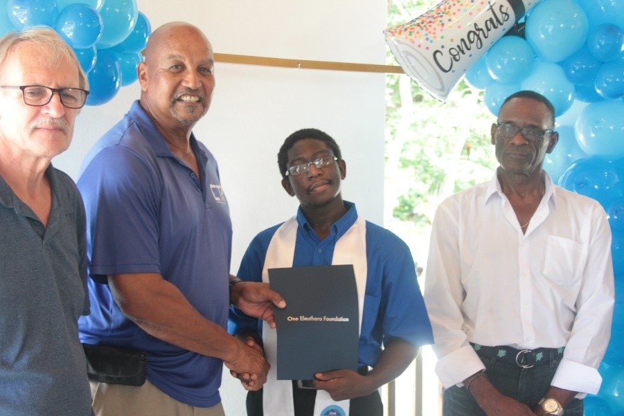 David Elliot a graduate from the Carpentry Cohort receives his certification surrounded by (from left to right) carpentry instructors Graham Walker, Larry Forbes, and guest speaker Gregory Higgs.