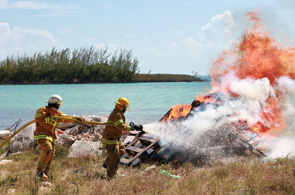 Local GHFR fire crew putting out a staged fire by the Fishermen's dock in Governor's Harbour.