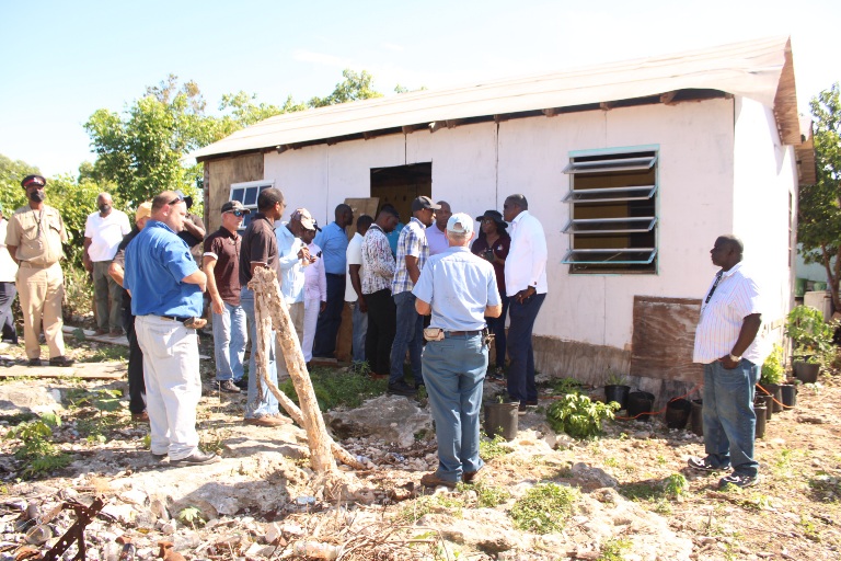 Minister Alfred Sears, along with his technical team, and local community leaders, inspect unregulated home construction in Blackwood, North Eleuthera.