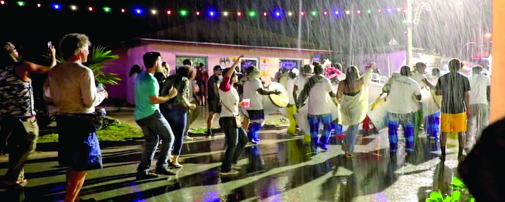 Revelers enjoying the sounds and sights of the junkanoo parade in Gregory Town, despite the rain.