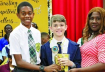 2022 Eleuthera District Spelling Bee Champion, Sohan Bryan, of Central Eleuthera High School, hands the winning trophy over to new 2023 Eleuthera District Spelling Bee Champion, Wes Underwood of Samuel Guy Pinder All Age.  They are accompanied by Mrs. Melinda Wallace with the Constituency Office.