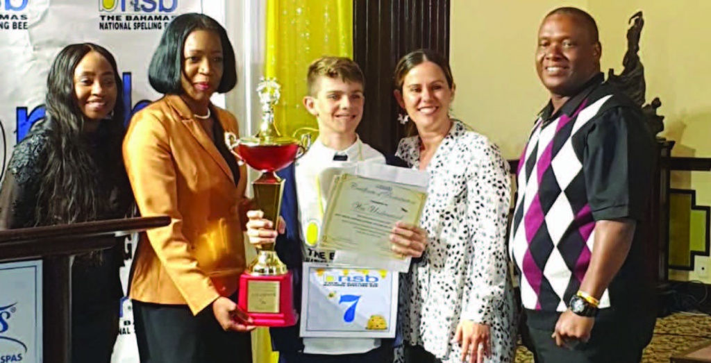 Wes accepts his winner's trophy from National Spelling Bee executives, along with his mother, Natalia Underwood, and his coach Bevil Clarke.
