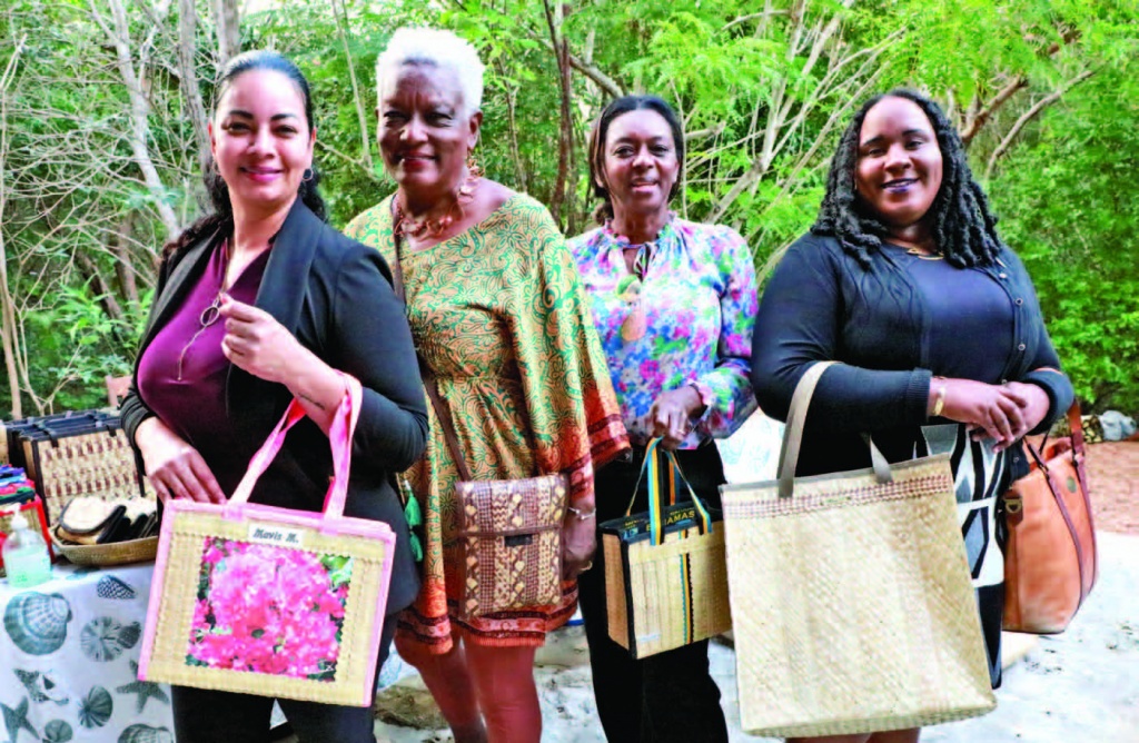 Staff from the One Eleuthera Foundation/CTI, stand with signature straw work artisan, Emily Mavis Munnings (second from left), showing off new purchases of designer hand bags, during the winter residents reception.
