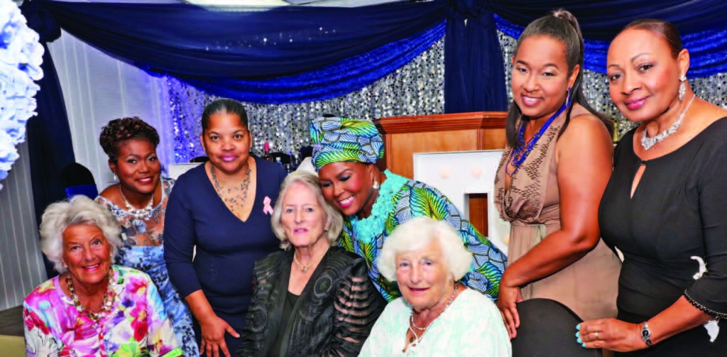 A warm moment at The Hope Ball as CSE vice president Jacqueline Gibson (4th from right) embraces Cancer Society of the Bahamas president Susan Roberts (4th from left), surrounded by visiting friends, survivors and board members.
