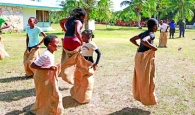 Local children compete in a fun sack race, guided by visiting GGYA leaders from throughout The Bahamas.